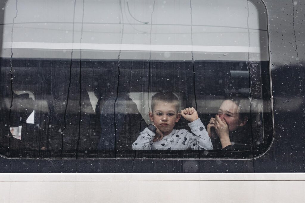 Un niño y su madre observan desde un tren en la estación de tren de Kiev