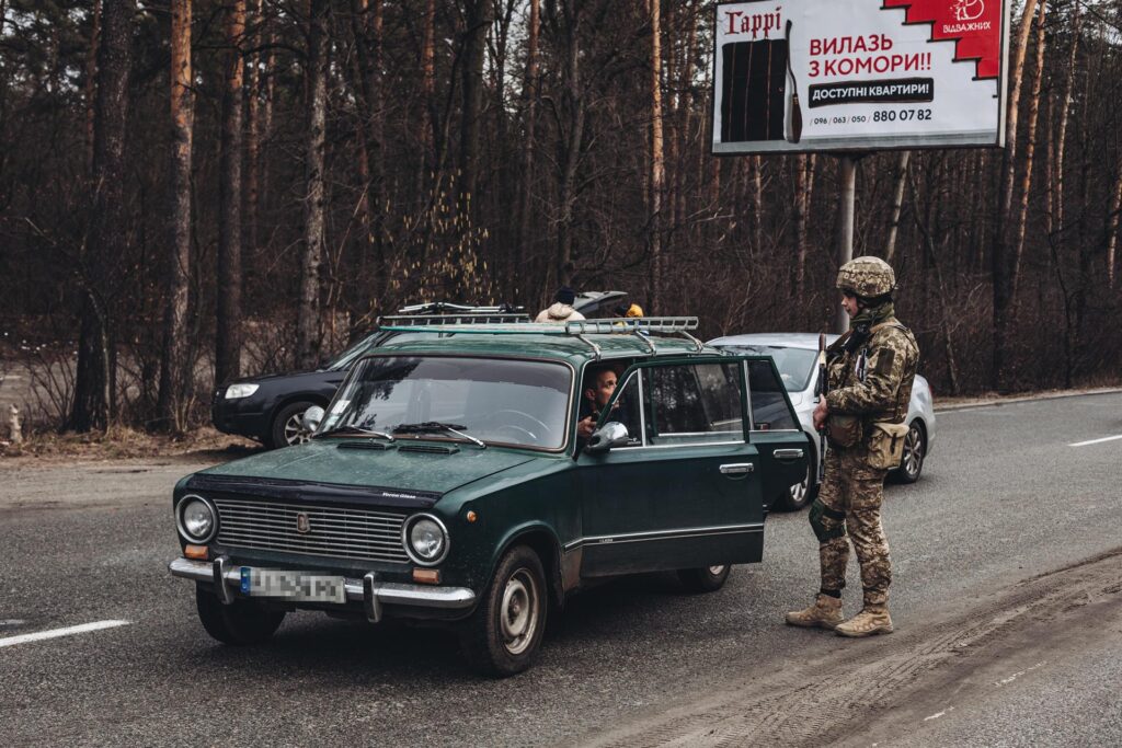 Un soldado del ejército ucraniano comprueba la documentación de un civil que huye de Irpin