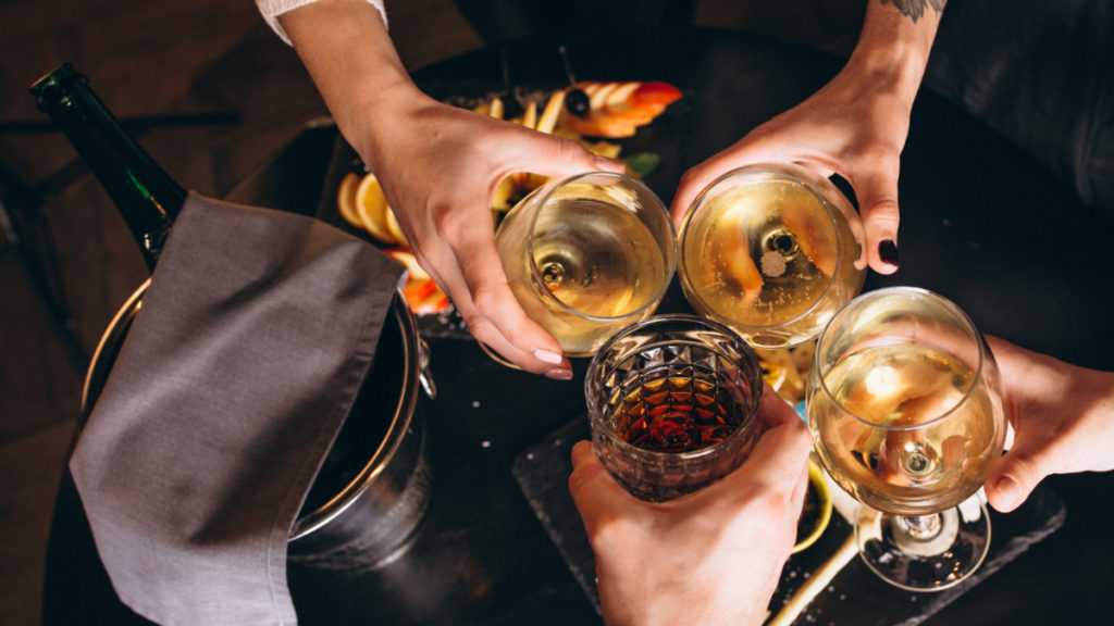 Several people holding glasses of alcohol, a trigger for fatty liver